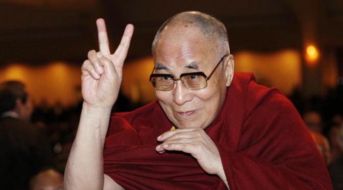 The Dalai Lama directs a peace sign toward the head table, where US President Barack Obama was seated, during the National Prayer Breakfast in Washington, DC, on 5 February 2015.